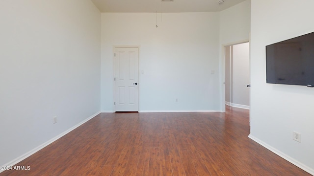 7171 W Quarter Horse Run, Coolidge, AZ 85128 - empty room with baseboards, a towering ceiling, and wood finished floors