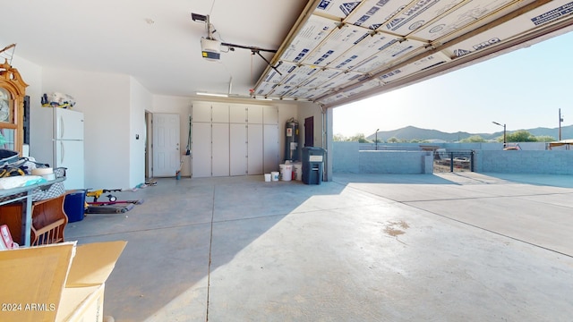 7171 W Quarter Horse Run, Coolidge, AZ 85128 - garage with water heater, a garage door opener, a mountain view, and freestanding refrigerator