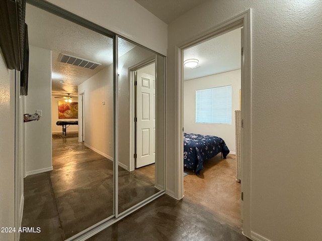 hall with a textured ceiling