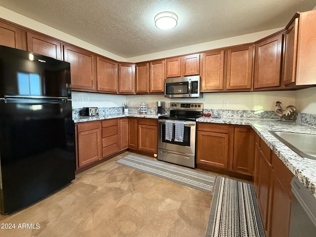 kitchen featuring light carpet, sink, light stone countertops, appliances with stainless steel finishes, and a textured ceiling