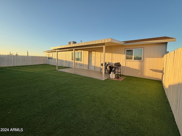 rear view of house with a patio and a lawn