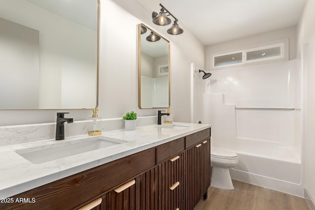 full bathroom featuring toilet, vanity, hardwood / wood-style floors, and bathing tub / shower combination