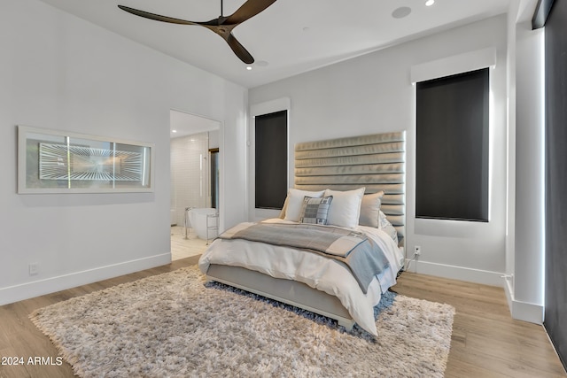 bedroom featuring ceiling fan, light wood-type flooring, and ensuite bathroom