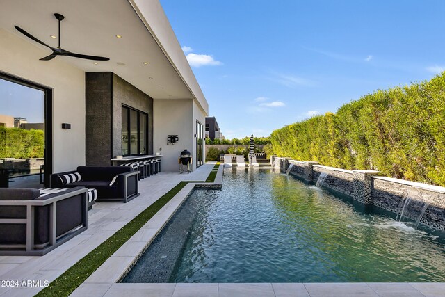 view of pool featuring pool water feature, an outdoor living space, a patio, and ceiling fan