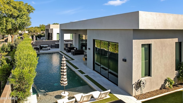 back of house featuring area for grilling, pool water feature, and a patio