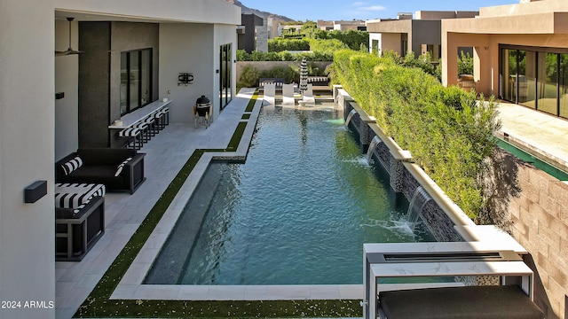 view of pool with a patio and pool water feature