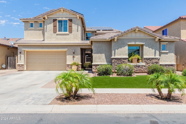 view of front of property featuring solar panels, a garage, and a front lawn