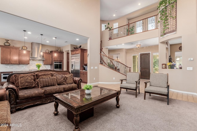 living room with a towering ceiling and carpet floors