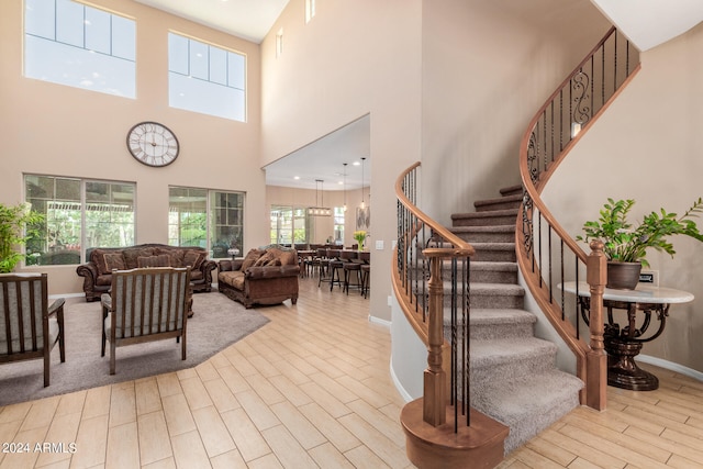 stairway featuring hardwood / wood-style floors and a high ceiling