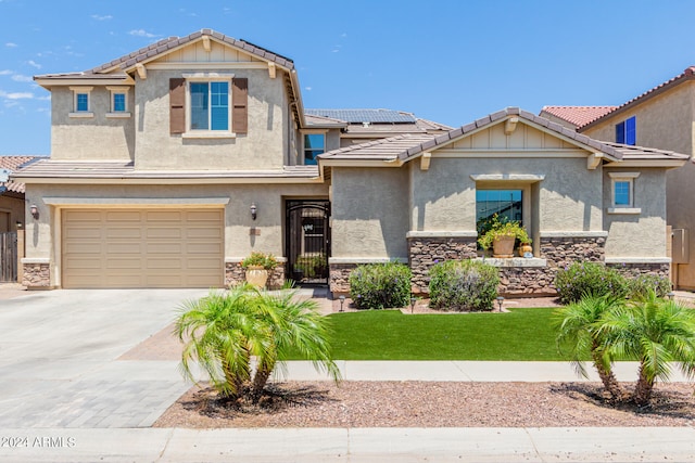 view of front of house with solar panels, a garage, and a front lawn