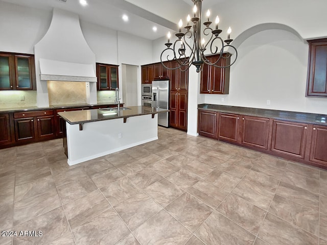 kitchen featuring a breakfast bar, custom exhaust hood, a center island with sink, sink, and stainless steel appliances