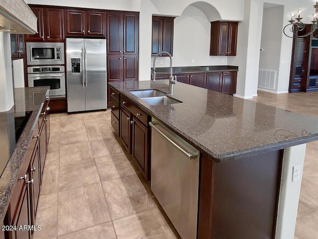 12446 W Bajada Rd, Peoria, AZ 85383 - kitchen with stainless steel appliances, a sink, a spacious island, dark stone countertops, and light tile patterned floors