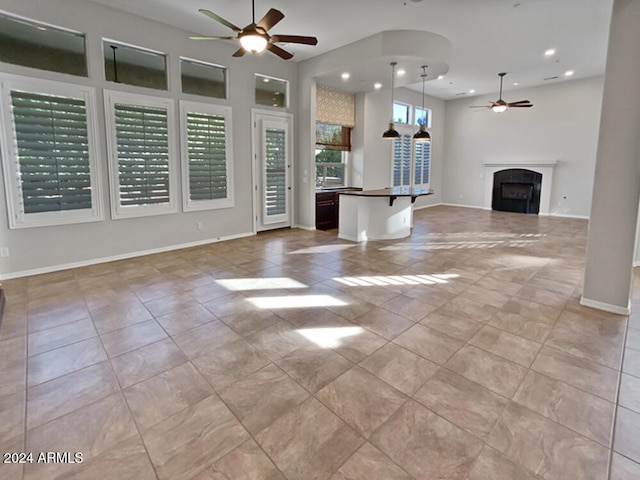 unfurnished living room with ceiling fan and light tile patterned floors