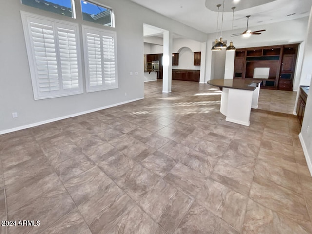 unfurnished living room featuring ceiling fan