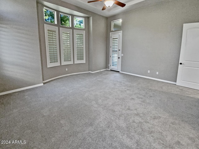 empty room featuring ceiling fan and carpet