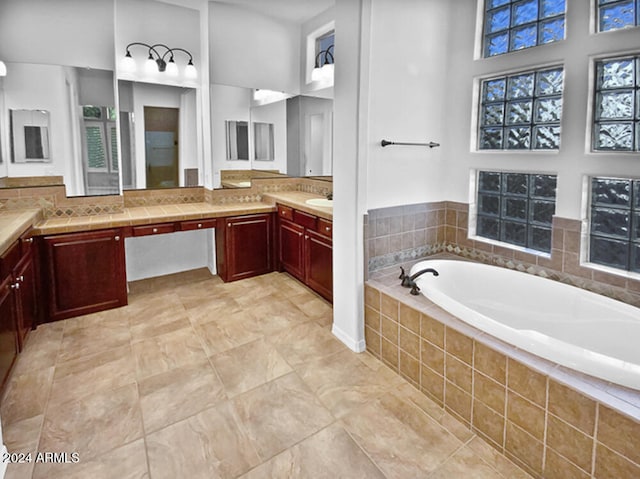 bathroom featuring a high ceiling, vanity, and tiled tub