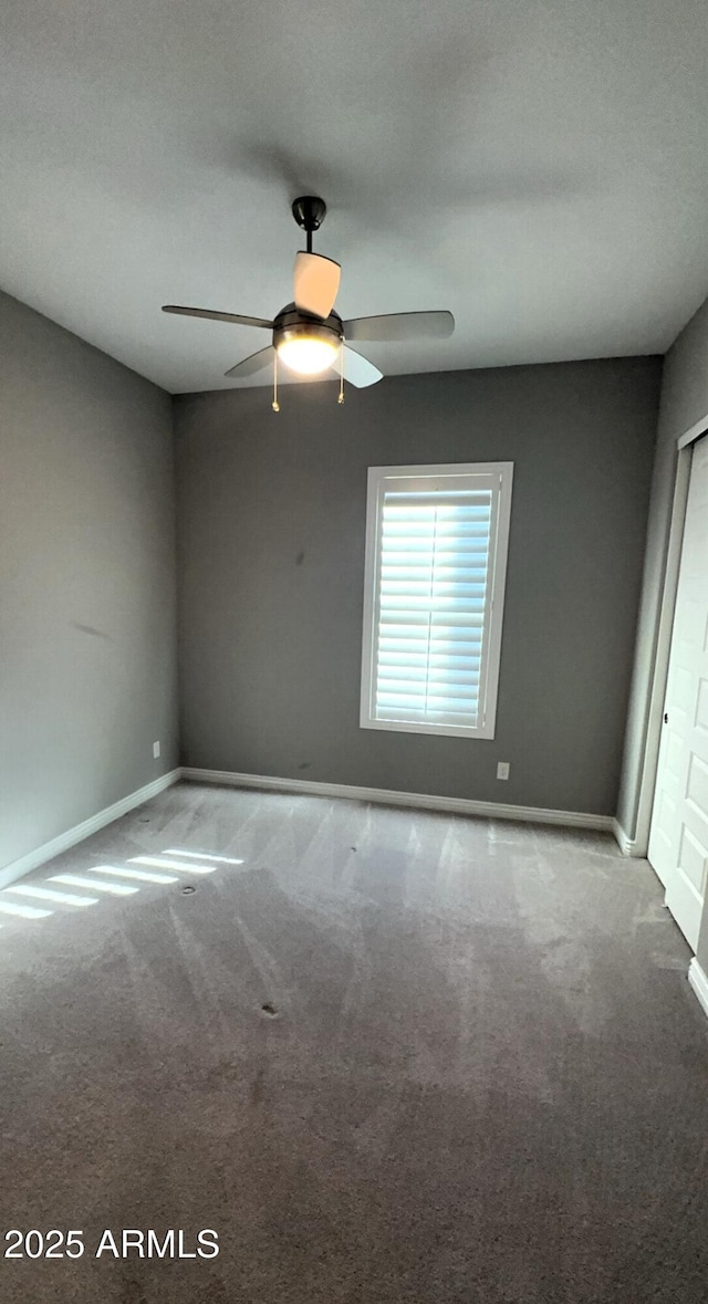 spare room with ceiling fan and carpet