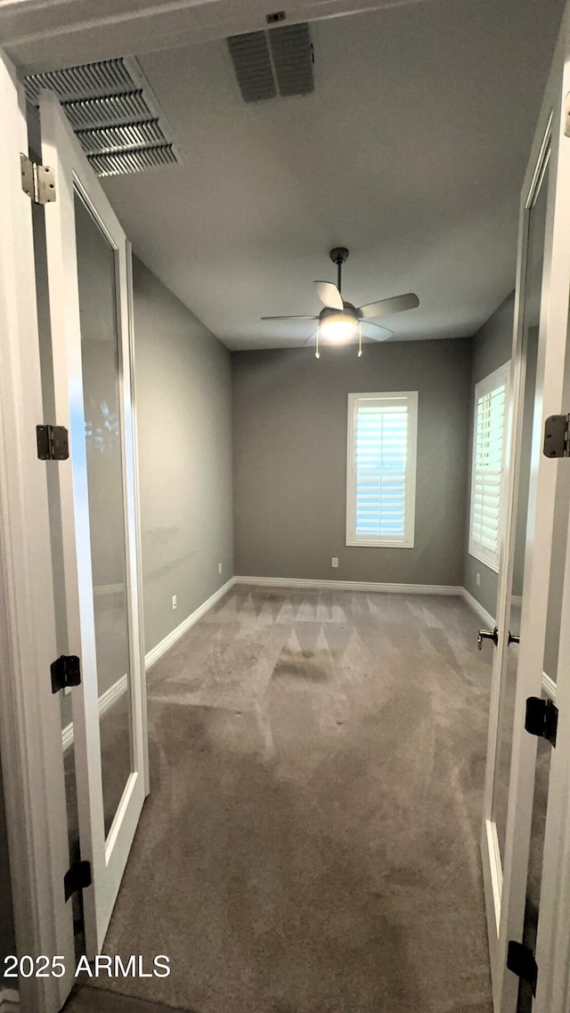 carpeted empty room with french doors and ceiling fan