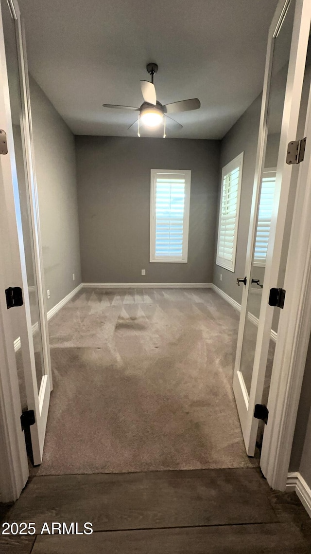 carpeted spare room with ceiling fan and french doors