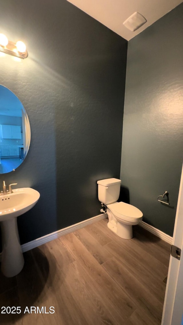 bathroom with hardwood / wood-style floors and toilet