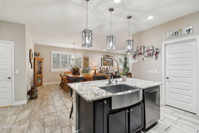 kitchen with pendant lighting, a center island with sink, and sink