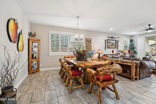 dining space with ceiling fan with notable chandelier