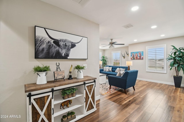 living room featuring wood-type flooring and ceiling fan