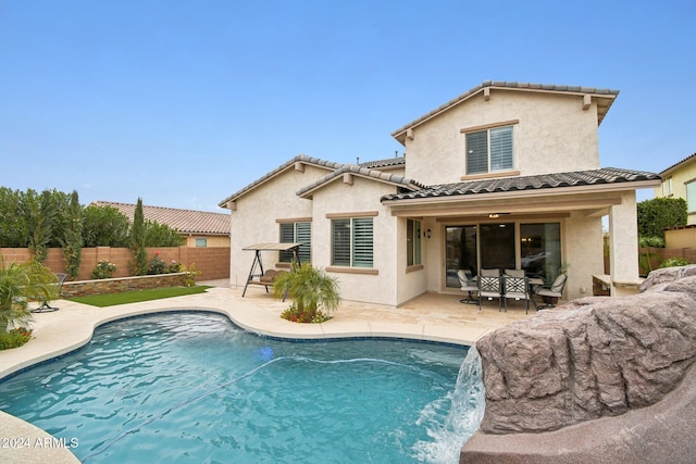 back of house featuring a fenced in pool, a patio area, and pool water feature