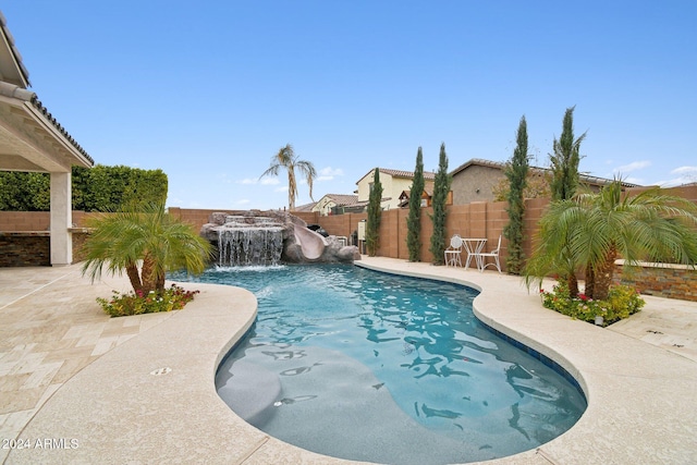 view of swimming pool with pool water feature, a patio, and a water slide