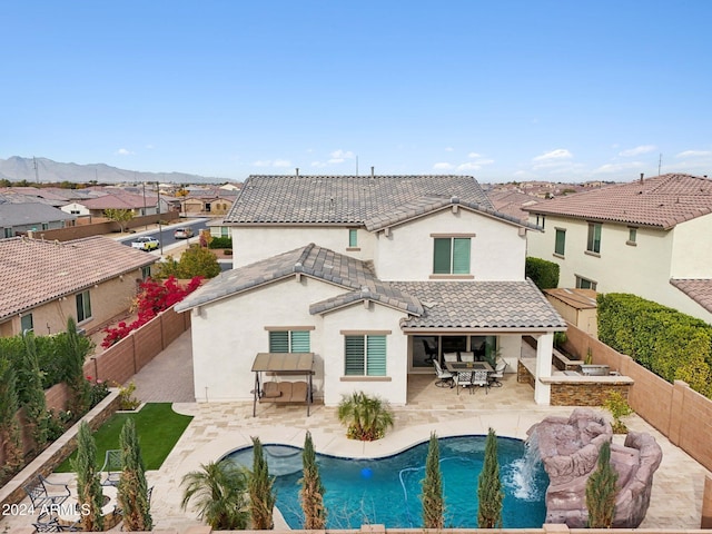 back of house featuring a fenced in pool, a patio area, and a mountain view