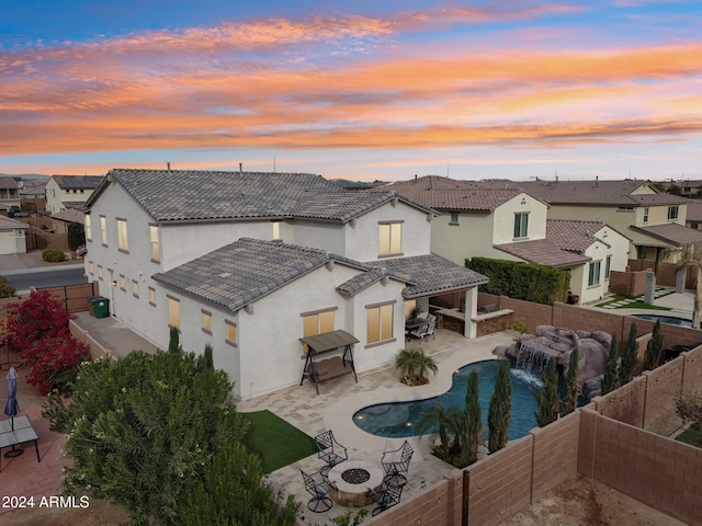 exterior space with a patio area, pool water feature, and an outdoor fire pit