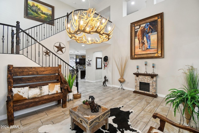 entryway featuring a fireplace, a high ceiling, and a chandelier