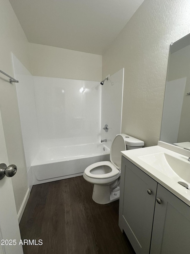 full bathroom with hardwood / wood-style flooring, vanity, toilet, and tub / shower combination