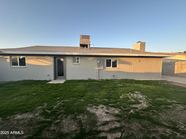 back of house featuring a lawn