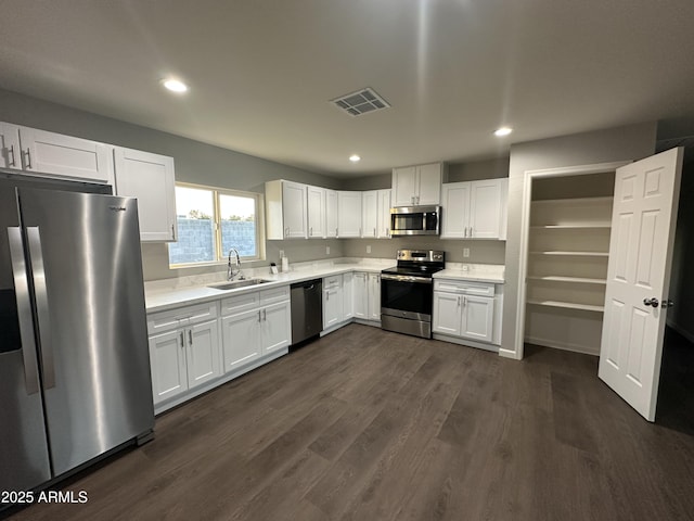 kitchen featuring sink, dark hardwood / wood-style floors, white cabinets, and appliances with stainless steel finishes