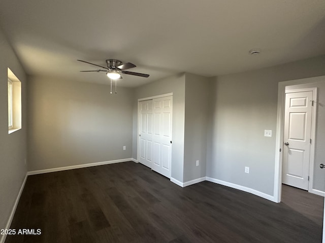 unfurnished bedroom with ceiling fan, dark hardwood / wood-style floors, and a closet