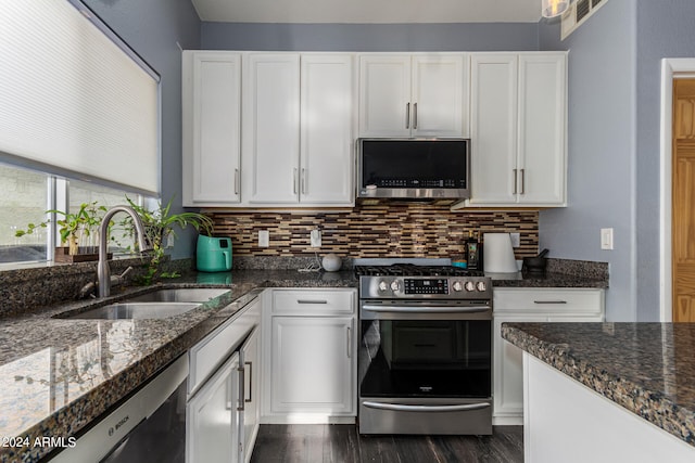 kitchen with dark stone counters, sink, stainless steel appliances, dark hardwood / wood-style floors, and white cabinetry