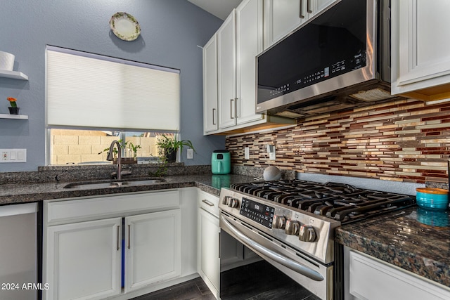 kitchen featuring appliances with stainless steel finishes, decorative backsplash, white cabinetry, and sink