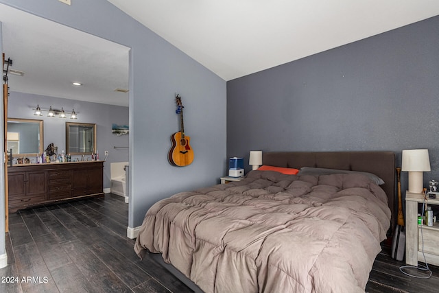 bedroom featuring lofted ceiling, ensuite bathroom, and dark wood-type flooring