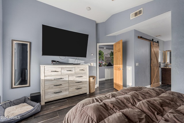 bedroom with a barn door and dark hardwood / wood-style flooring