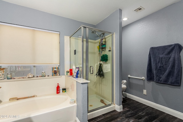 bathroom featuring hardwood / wood-style floors, separate shower and tub, and toilet