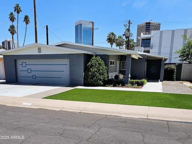 view of front of property with an attached garage, a front lawn, driveway, and brick siding