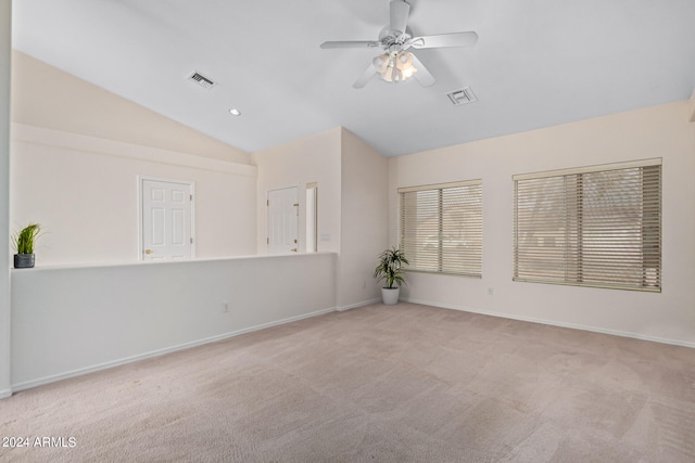 carpeted spare room with ceiling fan and vaulted ceiling