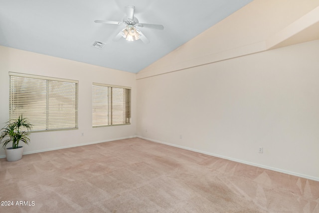 empty room with lofted ceiling, ceiling fan, and carpet floors