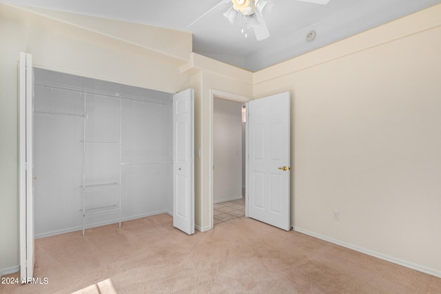 unfurnished bedroom with a closet, vaulted ceiling, ceiling fan, and light carpet