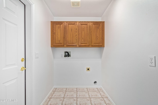 laundry room featuring hookup for an electric dryer, cabinets, and light tile flooring