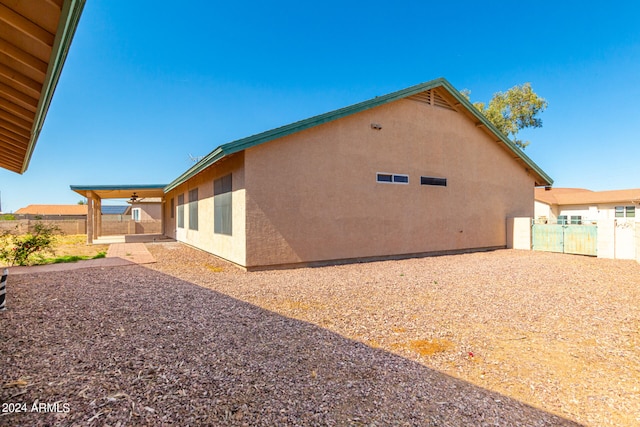 view of home's exterior with ceiling fan and a patio area