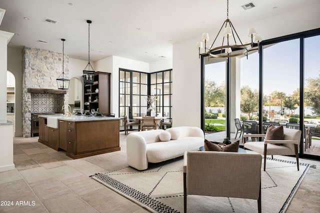 living room featuring plenty of natural light, sink, and a chandelier