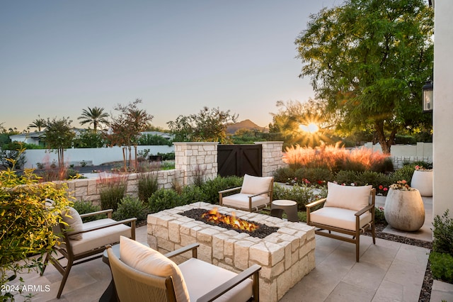 patio terrace at dusk featuring an outdoor fire pit