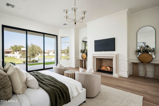 bedroom featuring wood-type flooring, ornamental molding, access to outside, and an inviting chandelier